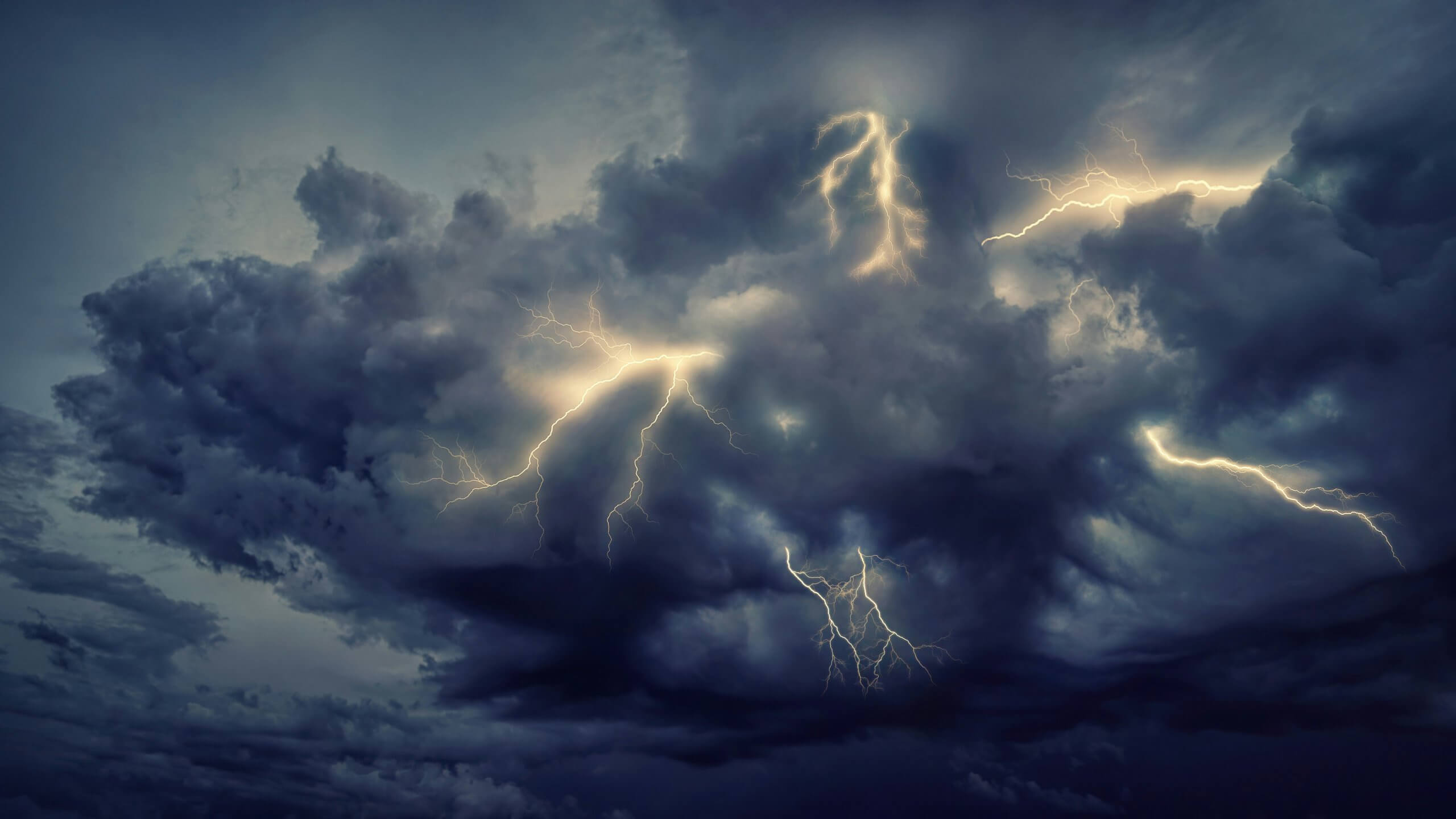 Dramatic thunderstorm clouds with multiple lightning bolts striking through. Navigating thunderstorms with children can be difficult but the tips in this blog can help you manage thunderstorms and child anxiety.