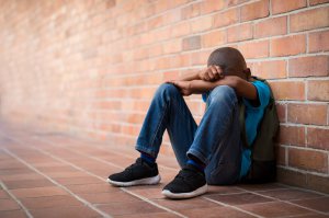 A child sits alone in a school hallway against the wall. Learn how child therapy in Scotch Plains, NJ can offer support with addressing anxiety by searching for anxiety counseling in Scotch Plains, NJ. They can offer child counseling in Branchburg, NJ and other services. 