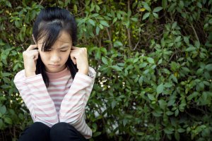 An Asian child plugs her ears with her fingers. This could represent social withdrawal as a part of anxiety. Learn more aobut anxiety counseling in Scotch Plains, NJ and the help that a child therapist in Scotch Plains, NJ can offer. Search for child therapy in New Jersey to learn more today.