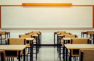 An empty classroom with wooden desks and chairs facing a whiteboard. This could represent the start of a new school year that child counseling in Branchburg, NJ can help you make the most of. Learn more about child counseling schotch plains, nj can help by searching for child therapy for anxiety today.