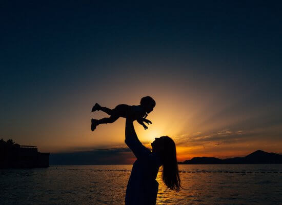 A silhouette of a mother holding their child above their head against the sunset. Learn how a child therapist in Branchburg, NJ can offer support by searching for child therapy in New Jersey. Child counseling in Branchburg, NJ can offer support today.