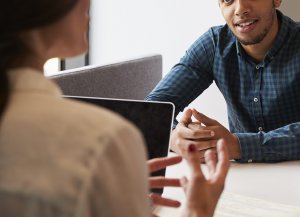 A close up of a parent sitting at a table across from a woman with a clipboard. This could represent meeting with a teacher for a parent-teacher conference. Learn more about anxiety treatment in Branchburg, NJ and how an anxiety therapist in Branchburg, NJ can offer support. Search for "signs of anxiety westfield, nj" to learn more. 