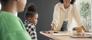 A teacher smiles while talking to a parent and a young student. This could represent the support child therapy in Branchburg, NJ can offer for children and parents. Search for EMDR therapy for children or child therapy for anxiety today. 