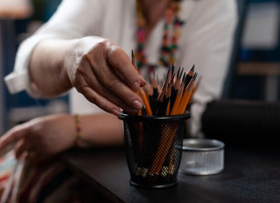 A close up of a teacher picking out a pencil from their holder. This could represent the stress of starting a new school year that anxiety treatment in Branchburg, NJ can help you and your child overcome. Learn more about the support an anxiety therapist in Branchburg, NJ can offer by searching for "anxiety in teens branchburg, nj" today.