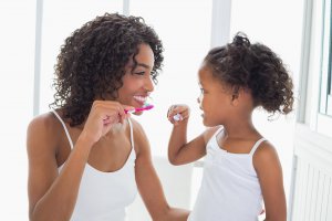 A mother and their child smile while brushing their teeth together. This could represent the benefits of routine for managing child anxiety. Contact a child therapist in Branchburg, NJ to learn more about child therapy for anxiety and other services. An anxiety therapist in Branchburg, NJ can help support you today.