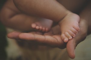 A close up of a parent holding the feet of their baby. This could represent the support therapists can offer for parenting in Branchburg, NJ. Search for parenting help Westfield, NJ to learn more about the support an online therapist New Jersey can offer. Search for a child therapist in Somerville, NJ today. 