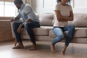 A couple sit on a couch while facing away from each other. This could symbolize a relationship issue that an infidelity counselor in Branchburg, NJ can help address. Learn more about couples counseling in Sommerville, NJ and how infidelity counseling can offer support today.