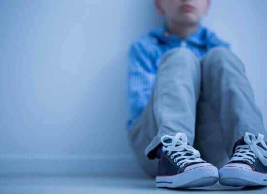 A close up of a child sitting alone with closed off body language. This could represent the stressors of mutism that a selective mutism therapist can address. Learn more about how selective mutism treatment in Branchburg, NJ and teach new tips on addressing childhood selective mutism in Branchburg, NJ today.