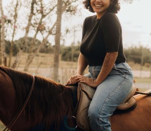 A young woman with short curly hair and a big smile sits on a brown horse, wearing a black top and jeans. Learn more about how Scotch Plains therapy and how an EMDR therapist in Branchburg, NJ can offer support. Search for equestrian therapy in New Jersey today. 